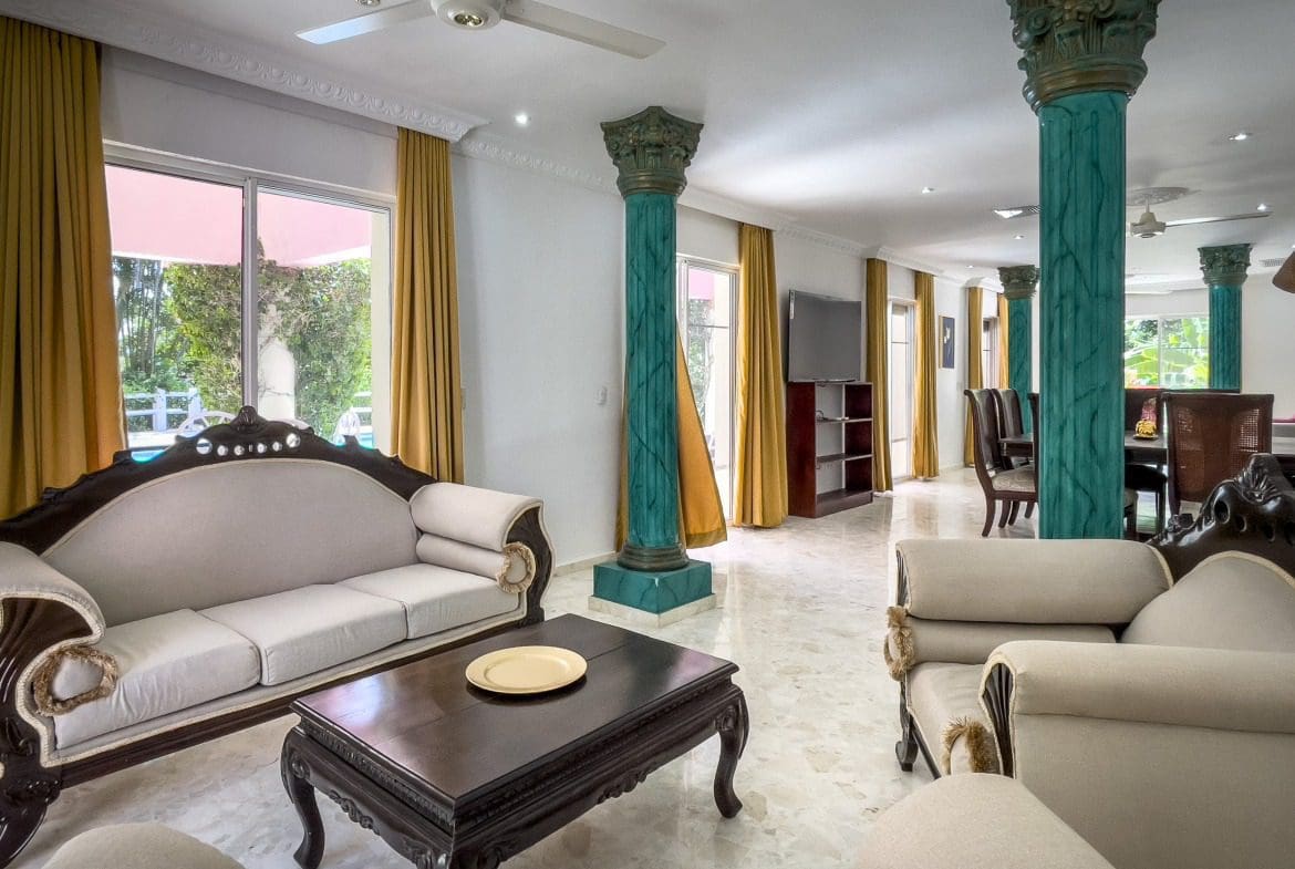 buyDRproperty Elegant living room with teal pillars and ornate furniture in a prime villa. Sosua Real Estate