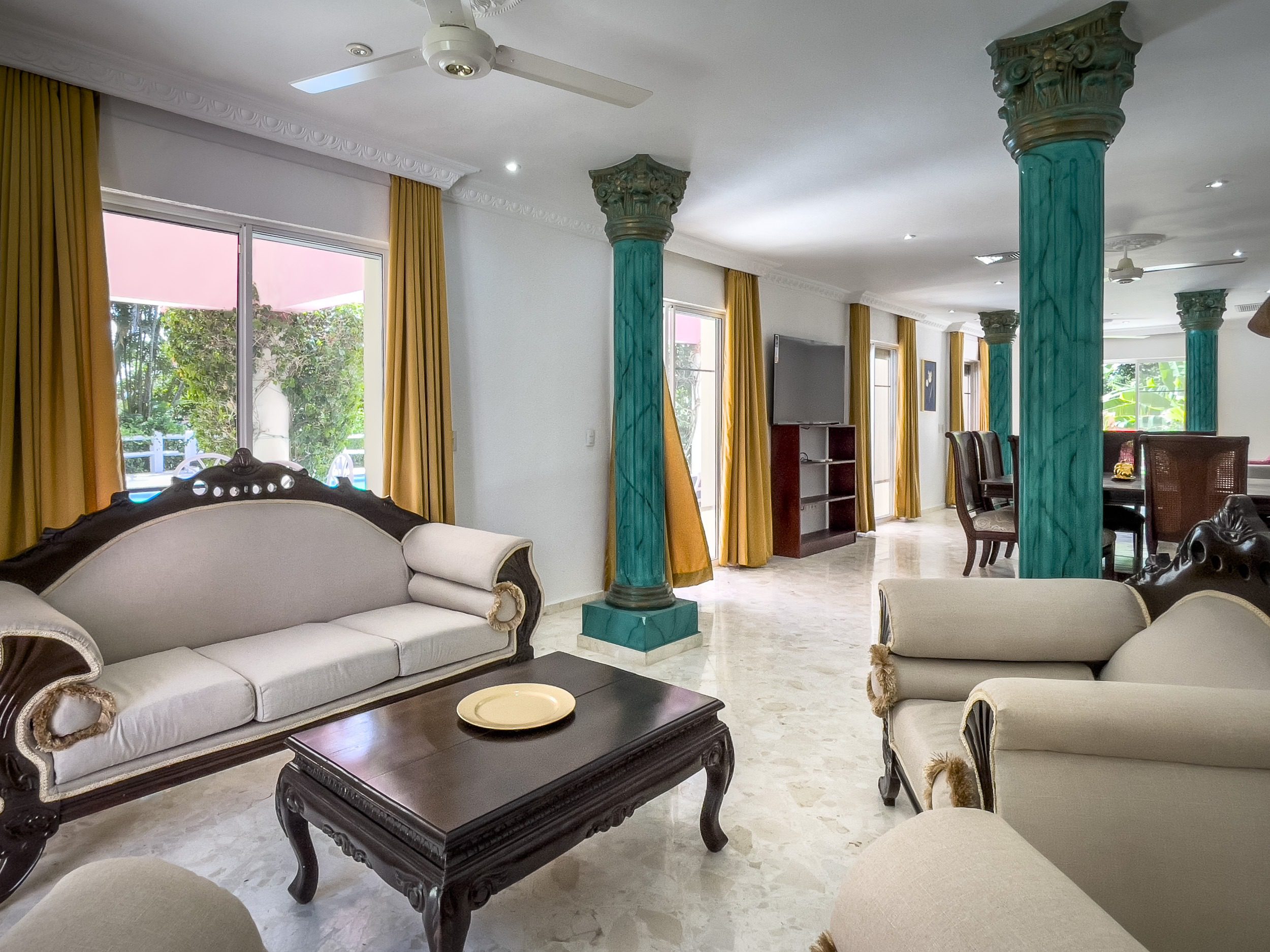 buyDRproperty Elegant living room with teal pillars and ornate furniture in a prime villa. Sosua Real Estate