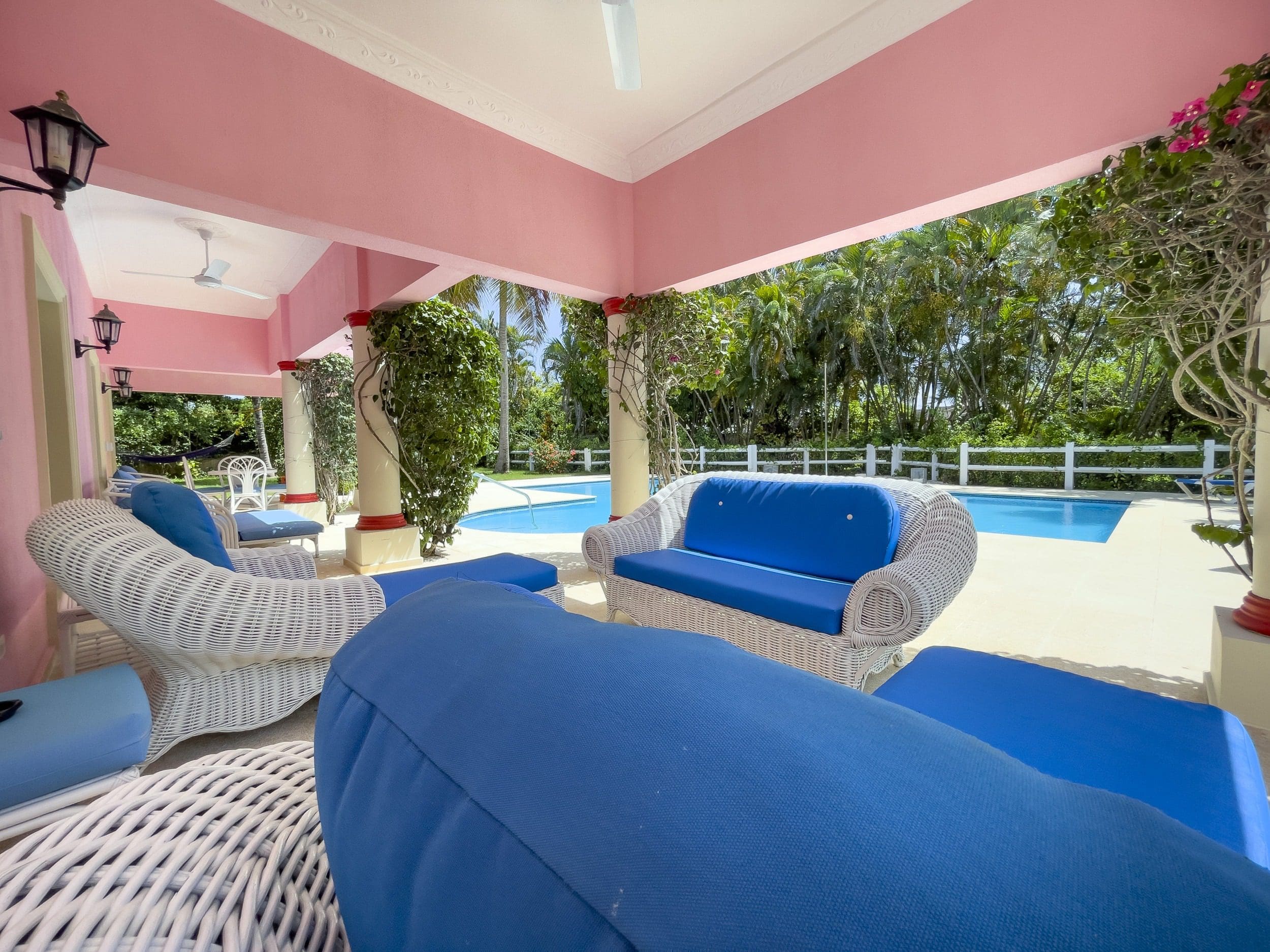 buyDRproperty Covered patio with white wicker furniture, blue cushions, and a pool. Prime villa. Sosua Real Estate