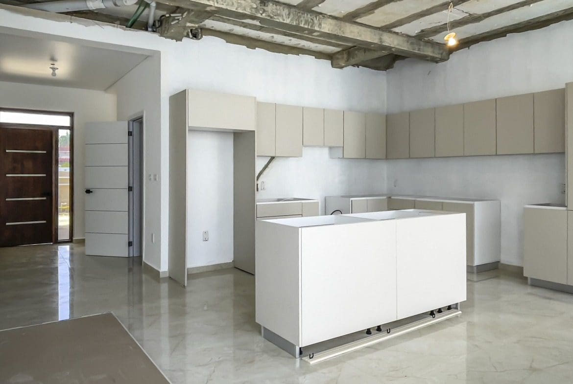 buyDRproperty Modern kitchen in condo for sale in Perla Marina with light cabinets and island. Sosua Real Estate