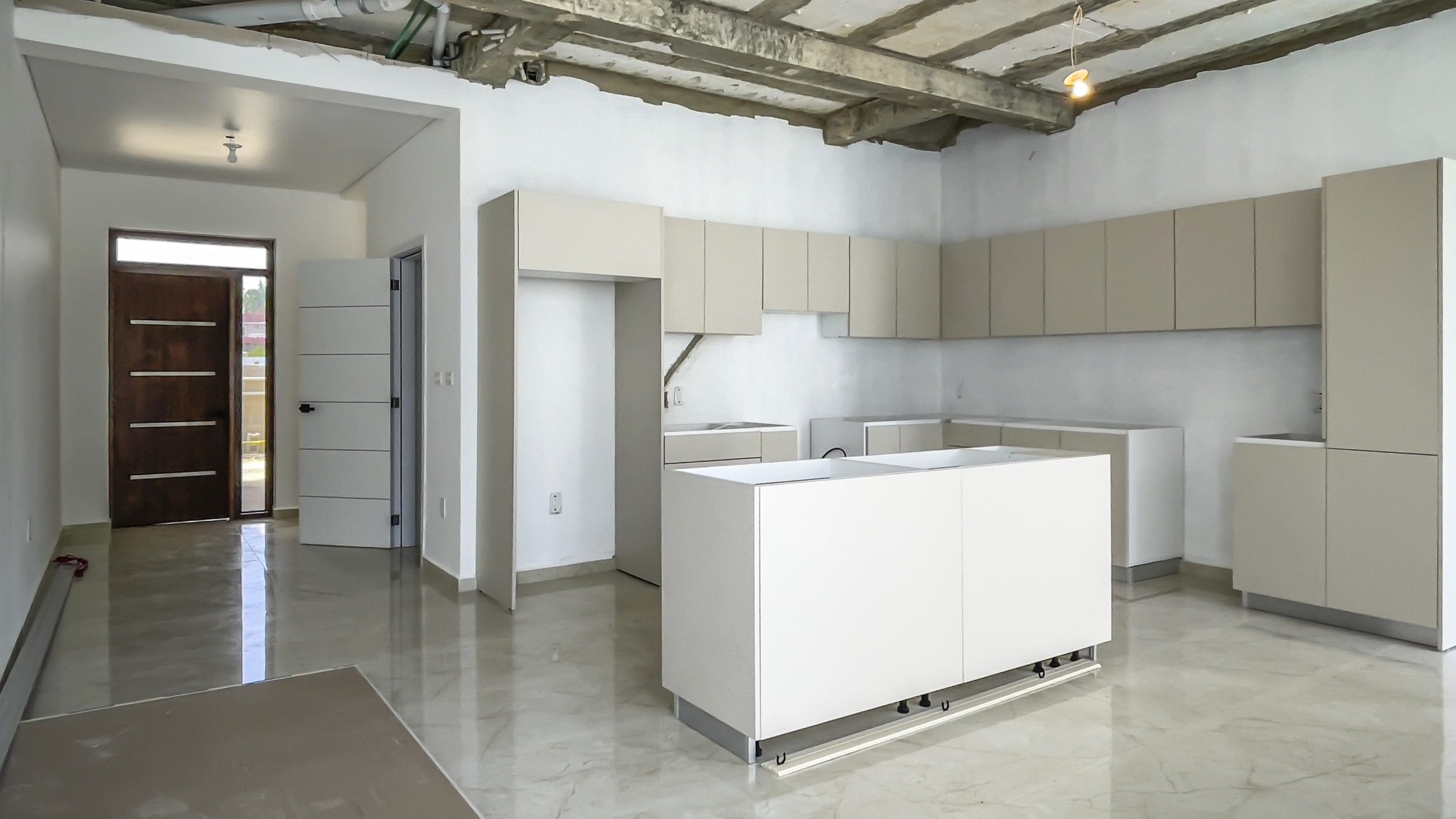 buyDRproperty Modern kitchen in condo for sale in Perla Marina with light cabinets and island. Sosua Real Estate