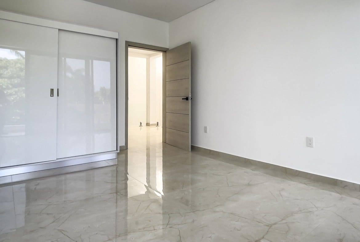 buyDRproperty Modern bedroom with white sliding closet doors and marble floor Sosua Real Estate