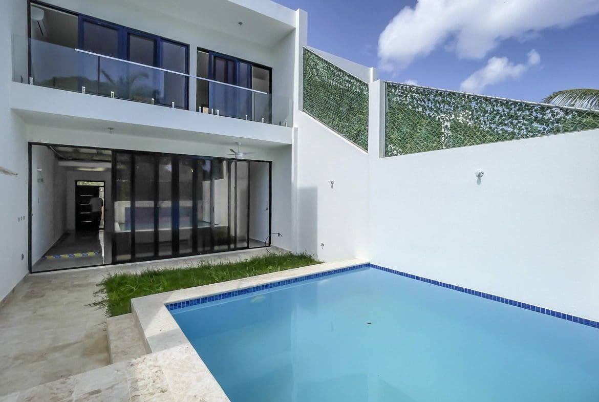 buyDRproperty Modern condo exterior with pool, glass balcony, and minimalist design Sosua Real Estate