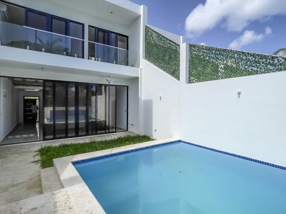 buyDRproperty Modern condo exterior with pool, glass balcony, and minimalist design Sosua Real Estate
