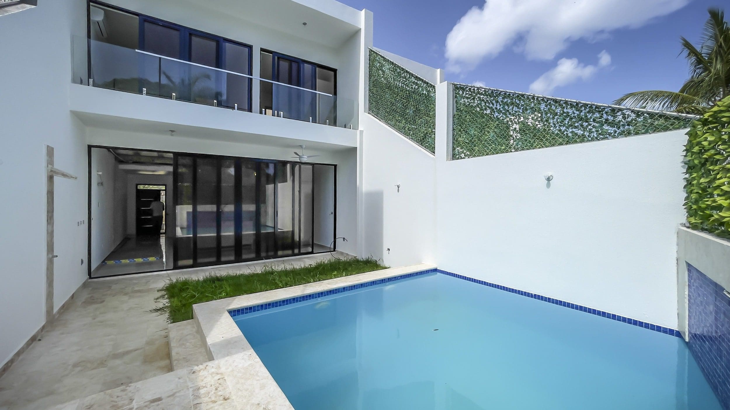 buyDRproperty Modern condo exterior with pool, glass balcony, and minimalist design Sosua Real Estate