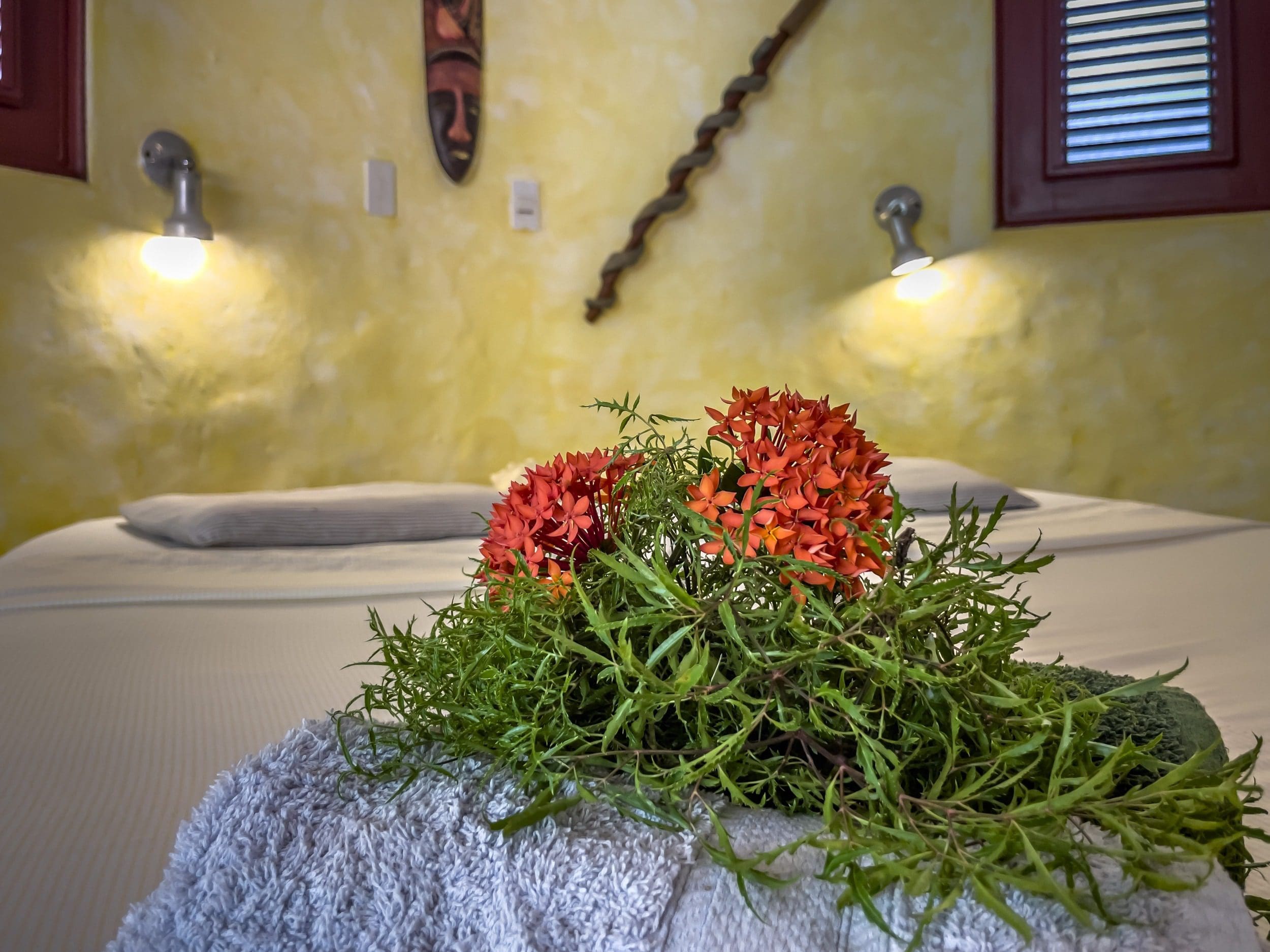 buyDRproperty Red flowers and greenery on a towel in a B&B bedroom Sosua Real Estate