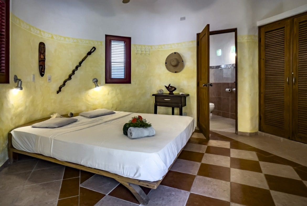 buyDRproperty Charming B&B bedroom with a large bed and rustic decor. Sosua Real Estate