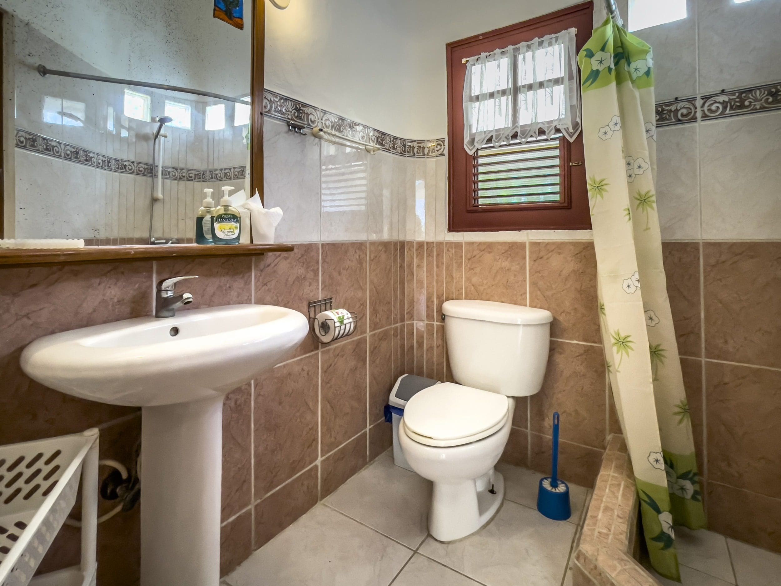 buyDRproperty Bathroom in a B&B with a white sink, toilet, and shower curtain. Sosua Real Estate