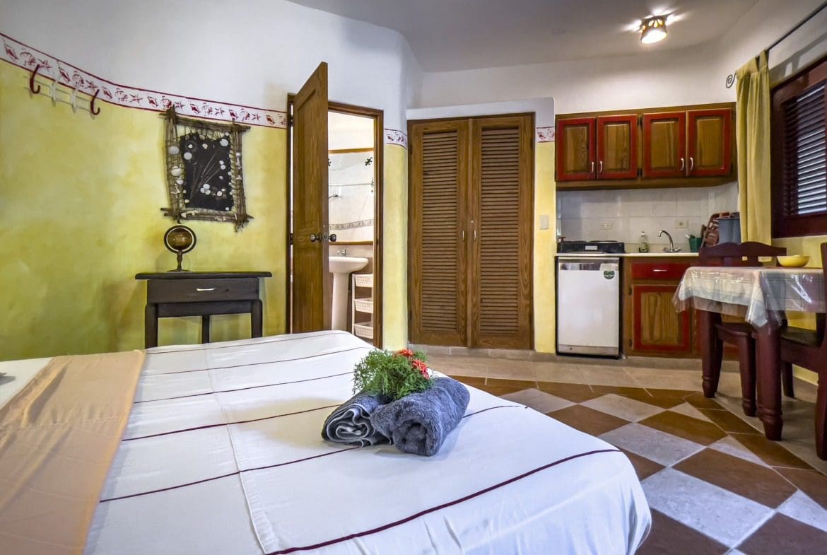 buyDRproperty Cozy B&B room with a bed, kitchenette, and bathroom access. Sosua Real Estate