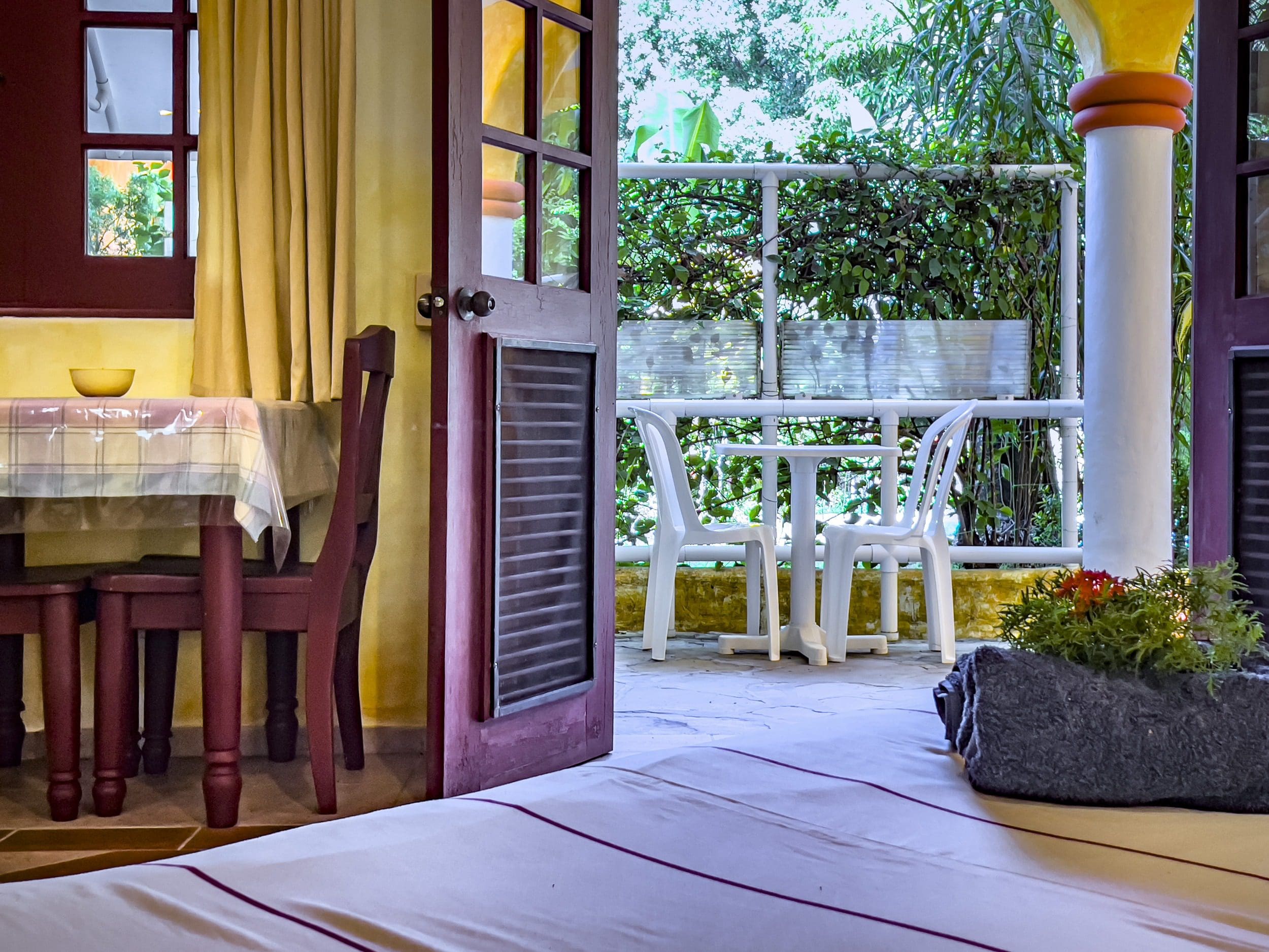 buyDRproperty Open door to a charming B&B patio with table and chairs. Sosua Real Estate