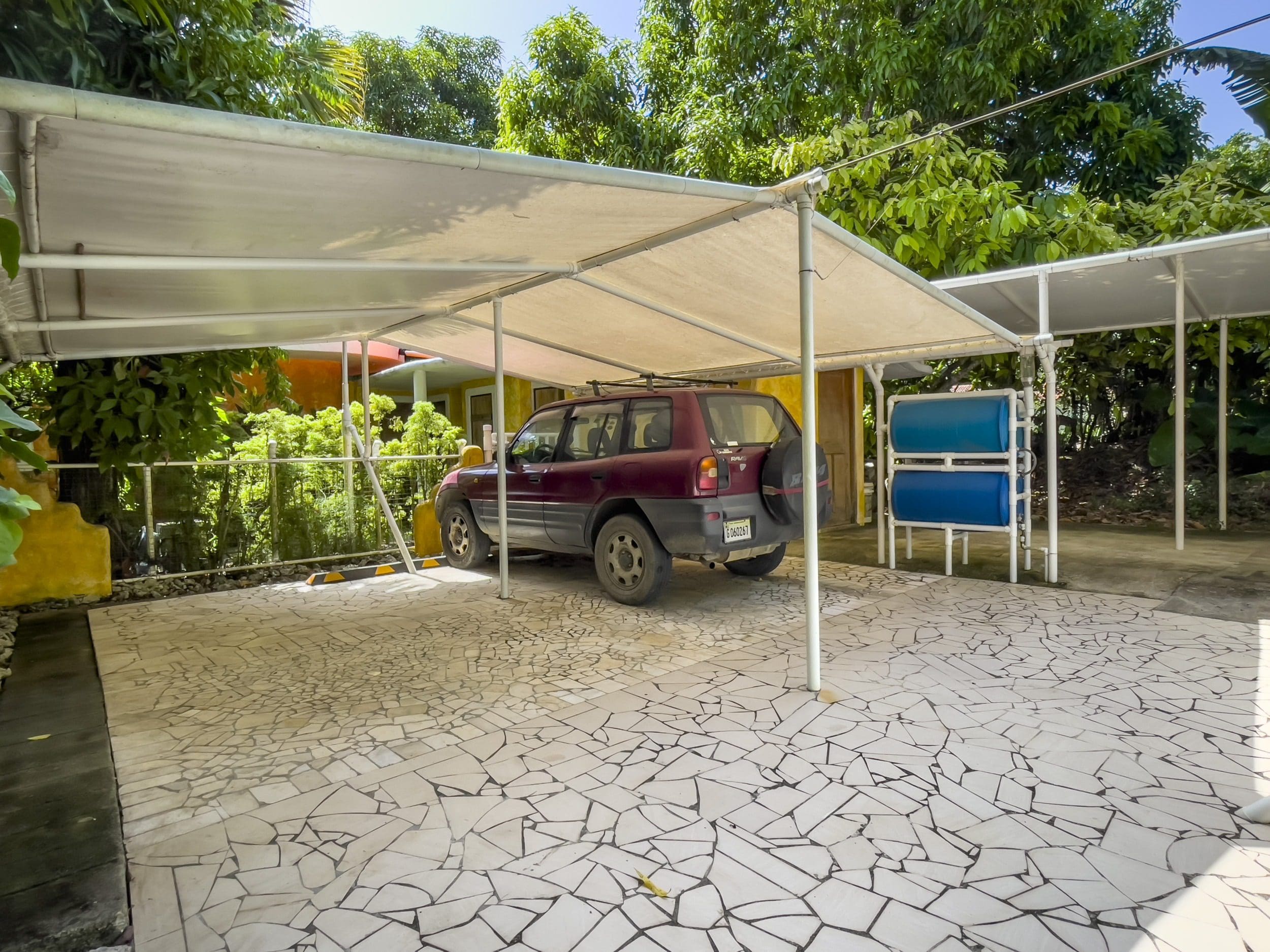 buyDRproperty Red SUV parked under a carport at a B&B Sosua Real Estate
