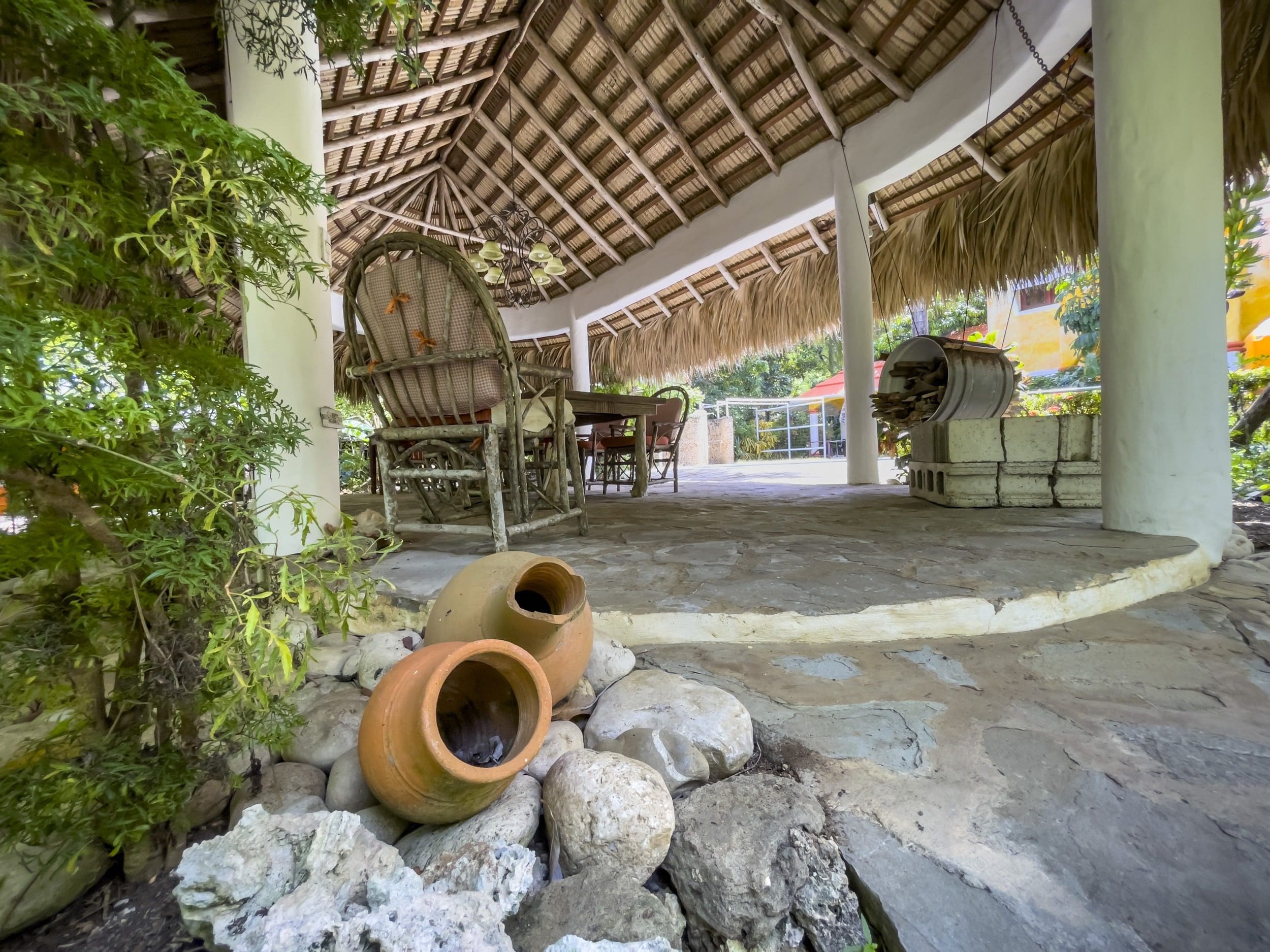 buyDRproperty Charming B&B outdoor dining area with thatched roof and stone flooring. Sosua Real Estate