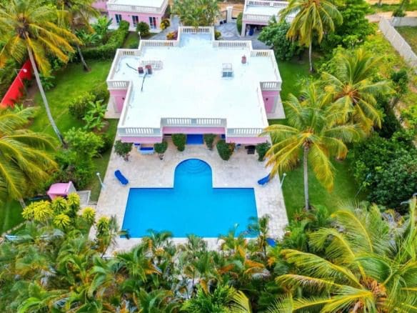 buyDRproperty Aerial view of a prime villa with a pool surrounded by palm trees. Sosua Real Estate