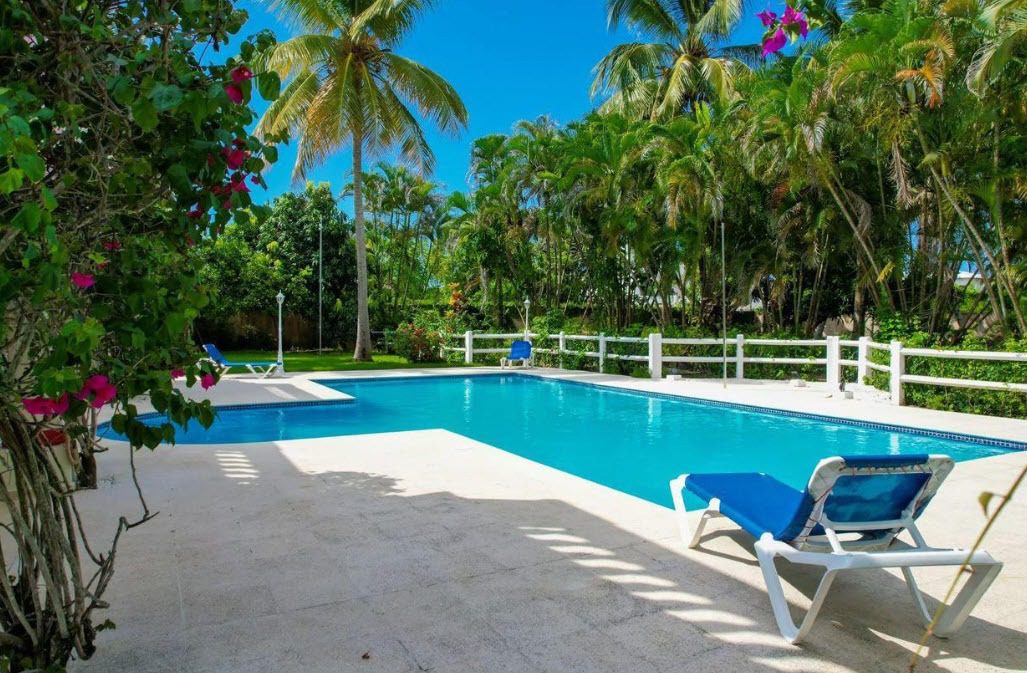 buyDRproperty Prime villa pool with lounge chair and tropical foliage Sosua Real Estate