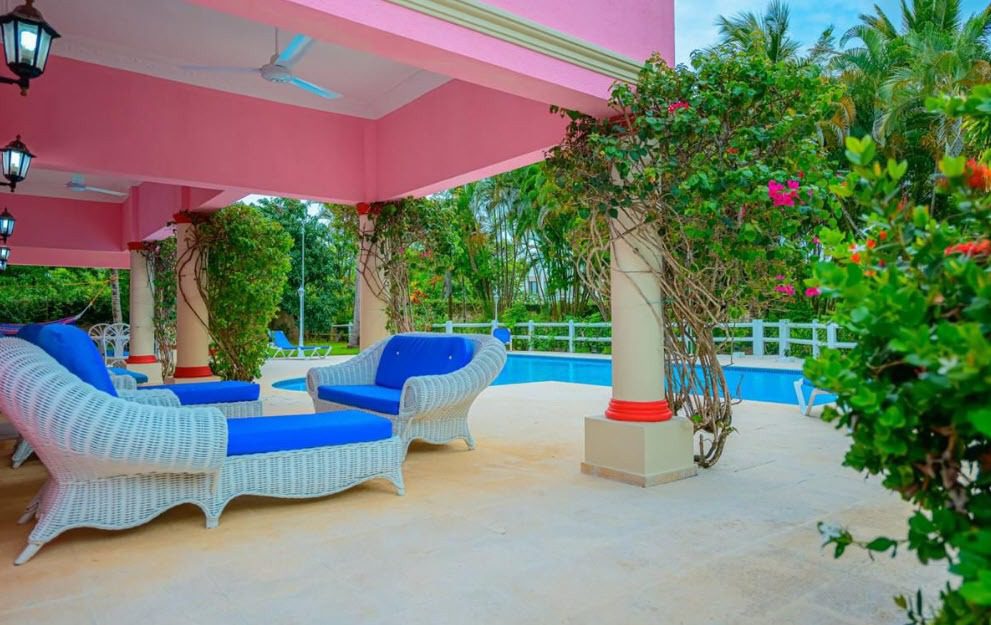 buyDRproperty Outdoor patio with blue furniture near a pool at a prime villa. Sosua Real Estate