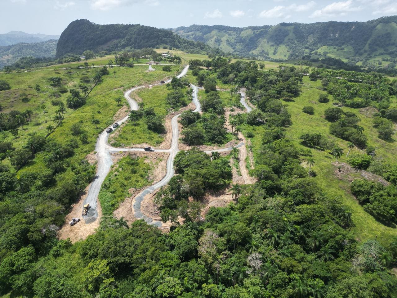 buyDRproperty Winding road through lush green hillside with mountain views. Sosua Real Estate