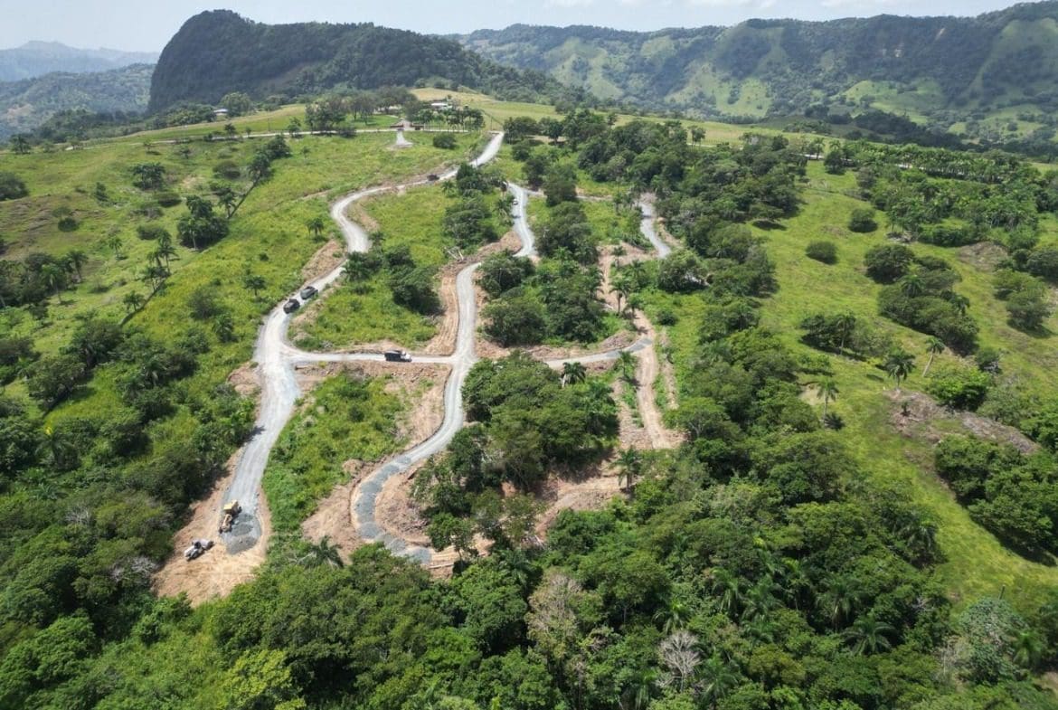 buyDRproperty Winding road cut through a green hillside with potential building lots, beautiful mountain views. Sosua Real Estate