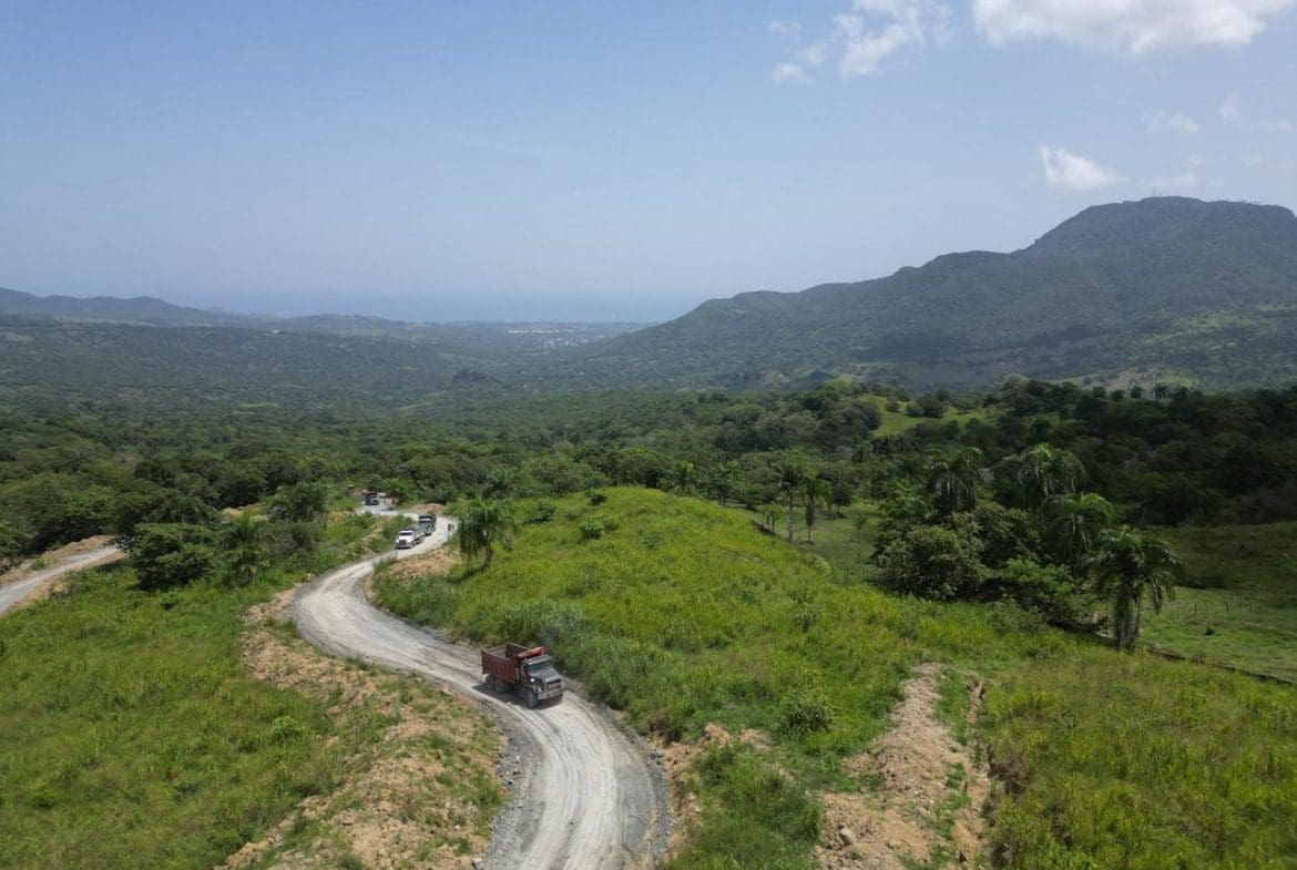 buyDRproperty Winding dirt road with truck through lush green mountains, beautiful mountain views. Sosua Real Estate