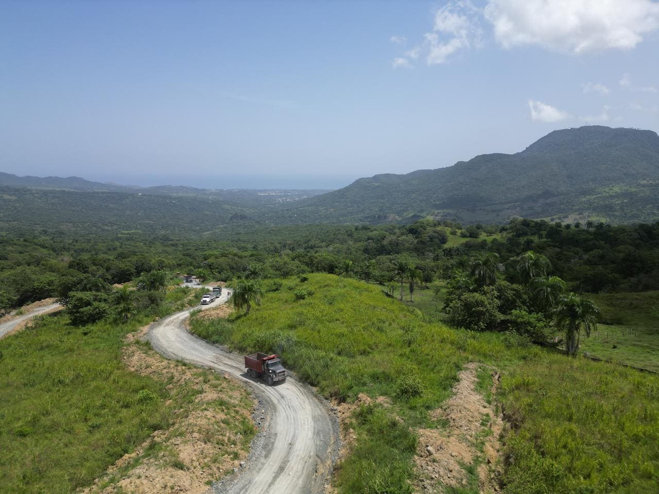 buyDRproperty Winding dirt road with truck through lush green mountains, beautiful mountain views. Sosua Real Estate