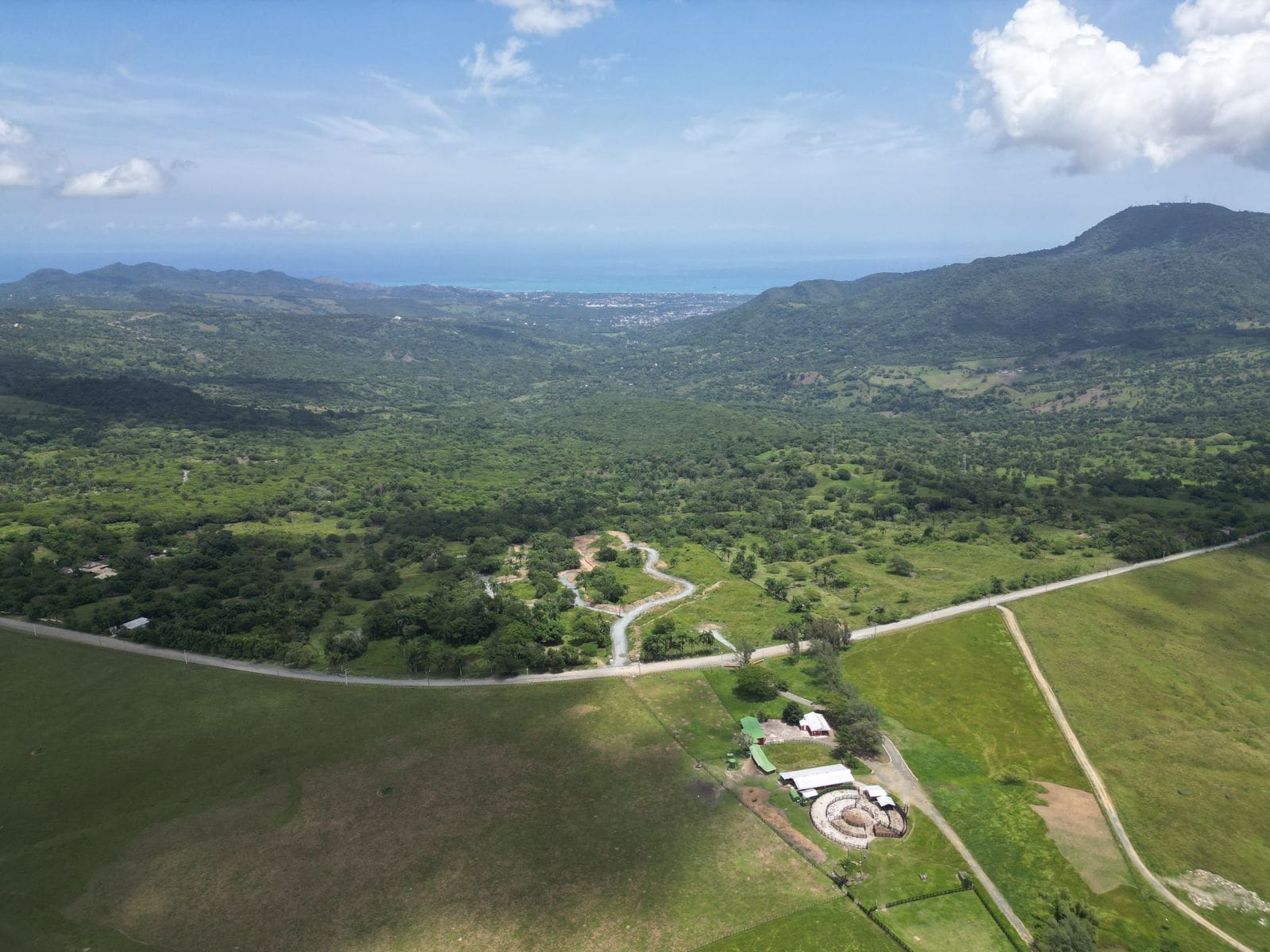 buyDRproperty Aerial view of countryside with mountains, roads, and a farm, perfect for building lots with mountain views. Sosua Real Estate