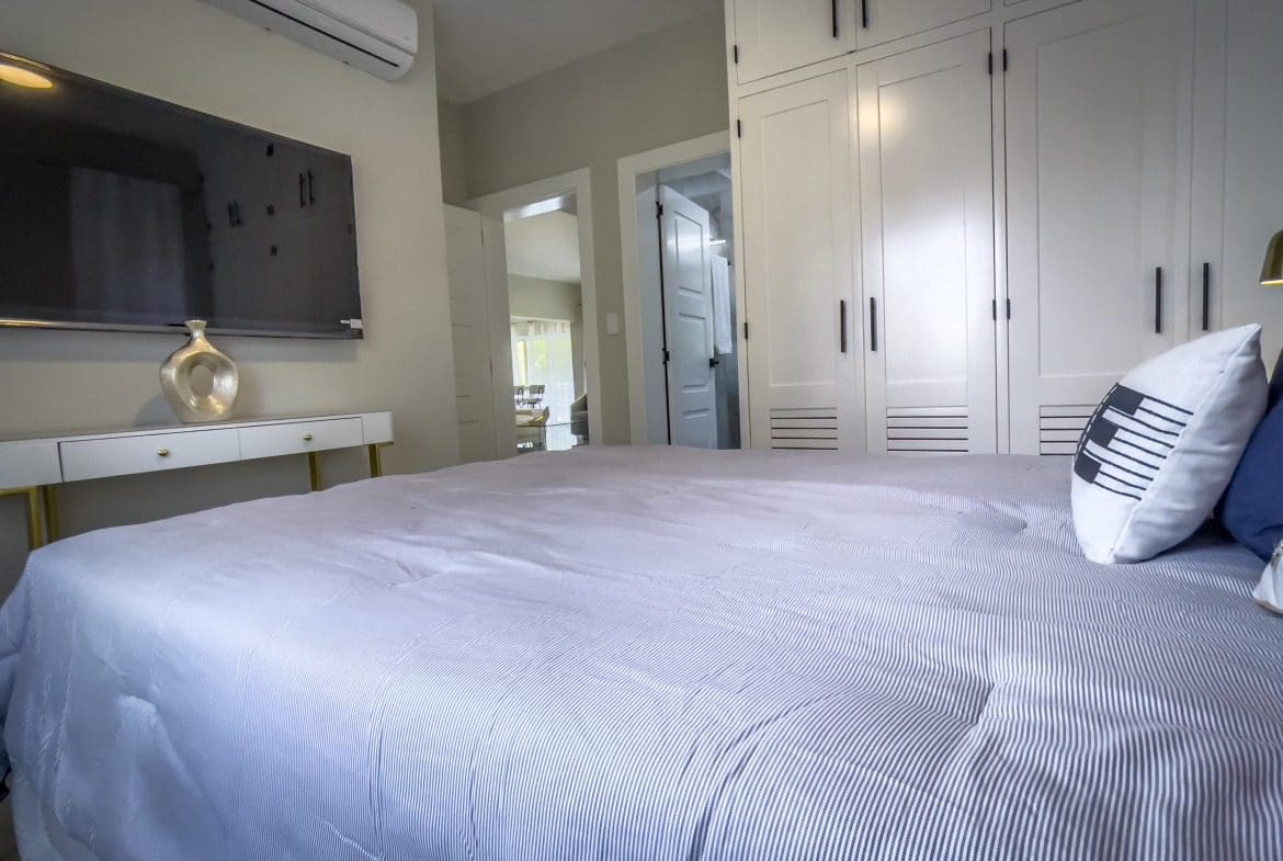 buyDRproperty Modern bedroom with a bed, TV, and built-in closet offering modern comfort. Sosua Real Estate