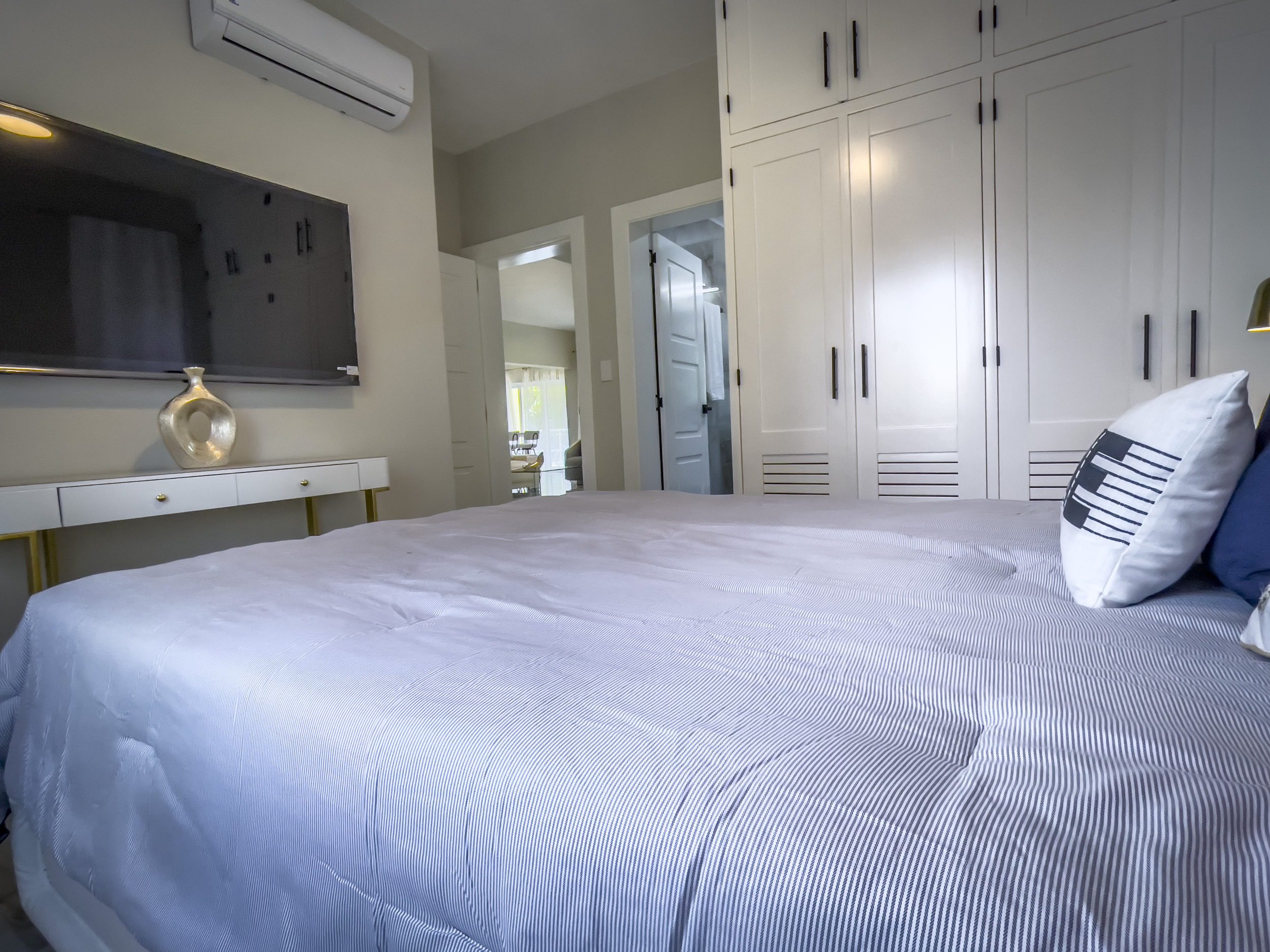 buyDRproperty Modern bedroom with a bed, TV, and built-in closet offering modern comfort. Sosua Real Estate