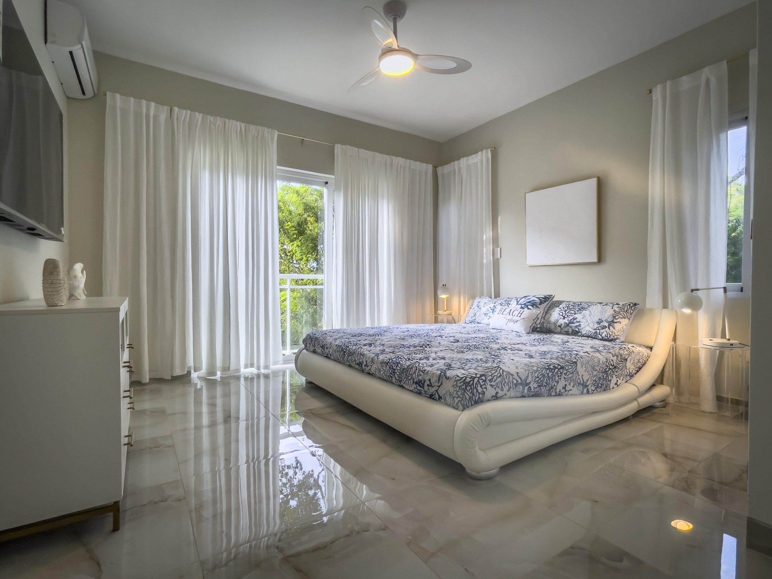 buyDRproperty Modern bedroom with a large bed, white curtains, and marble floor, offering modern comfort. Sosua Real Estate