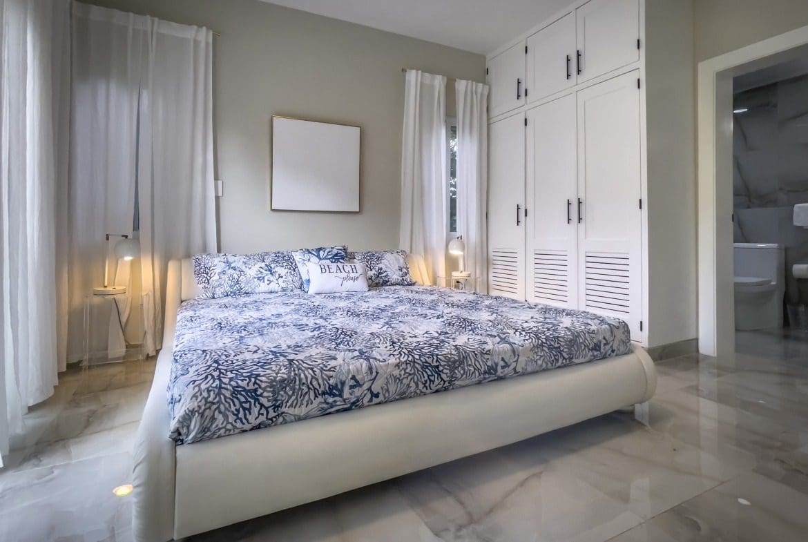 buyDRproperty Modern bedroom with large bed and white wardrobe, offering modern comfort. Sosua Real Estate