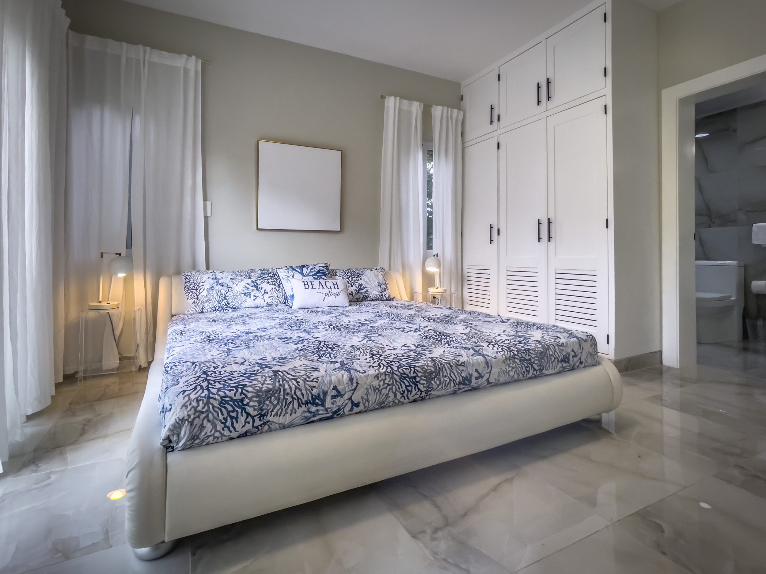 buyDRproperty Modern bedroom with large bed and white wardrobe, offering modern comfort. Sosua Real Estate