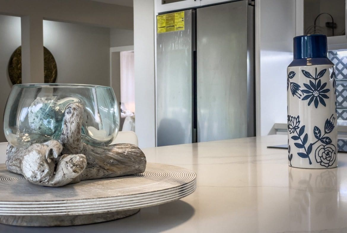 buyDRproperty Modern kitchen countertop with decorative glass bowl and floral vase, offering modern comfort. Sosua Real Estate