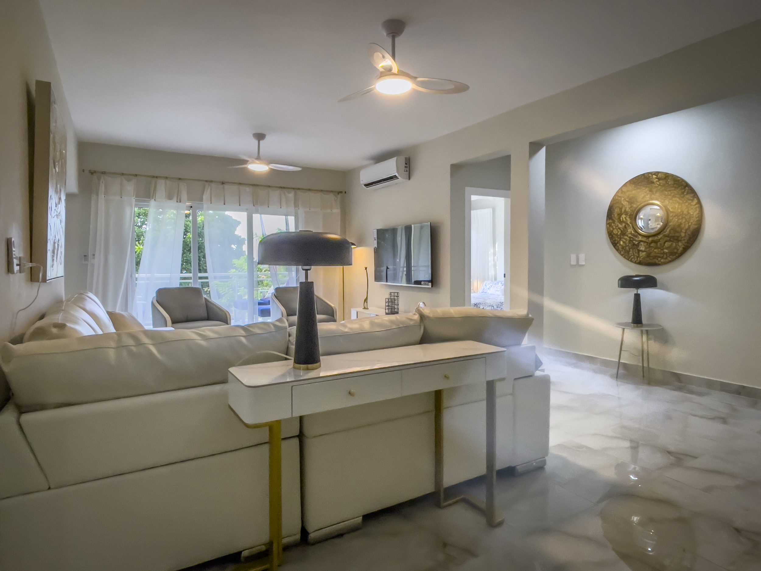 buyDRproperty Modern living room with white sofa and stylish decor, offering modern comfort. Sosua Real Estate