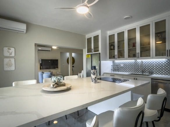 buyDRproperty Modern kitchen with white cabinets and a large island, offering modern comfort. Sosua Real Estate