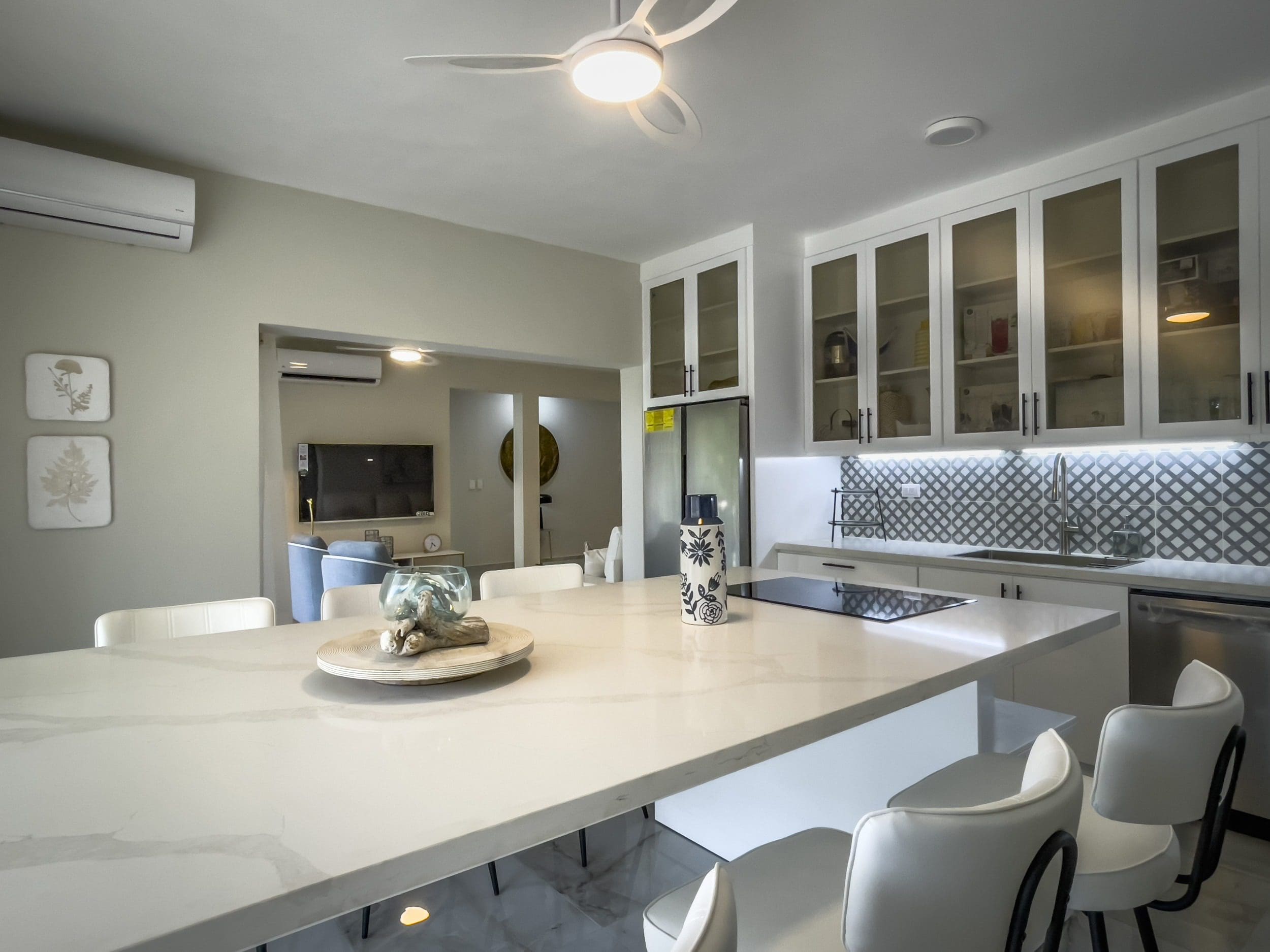 buyDRproperty Modern kitchen with white cabinets and a large island, offering modern comfort. Sosua Real Estate
