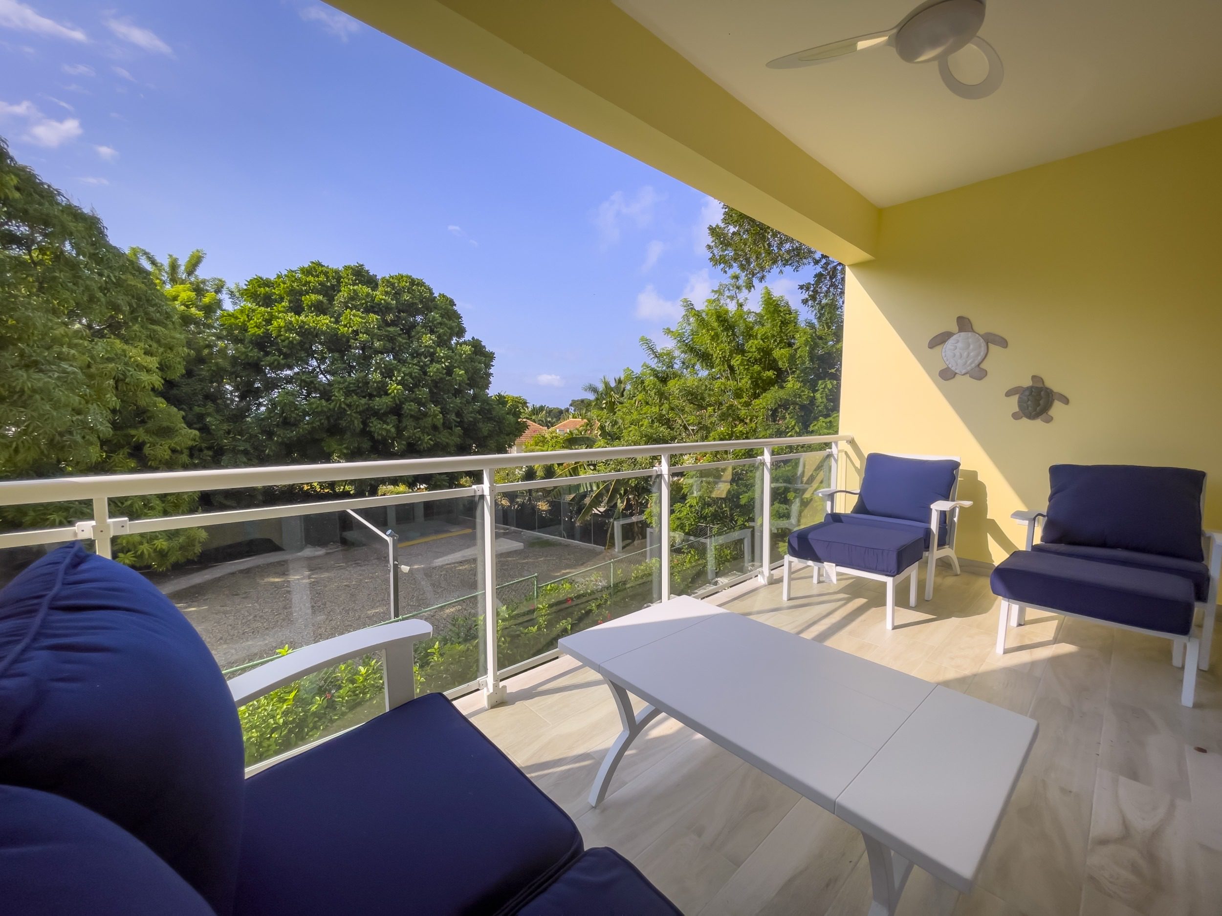 buyDRproperty Balcony with blue chairs and white table offers modern comfort with a view. Sosua Real Estate