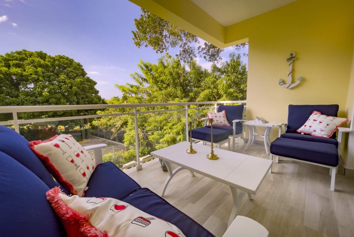 buyDRproperty Cozy outdoor seating area with blue cushions and pillows, offering modern comfort Sosua Real Estate