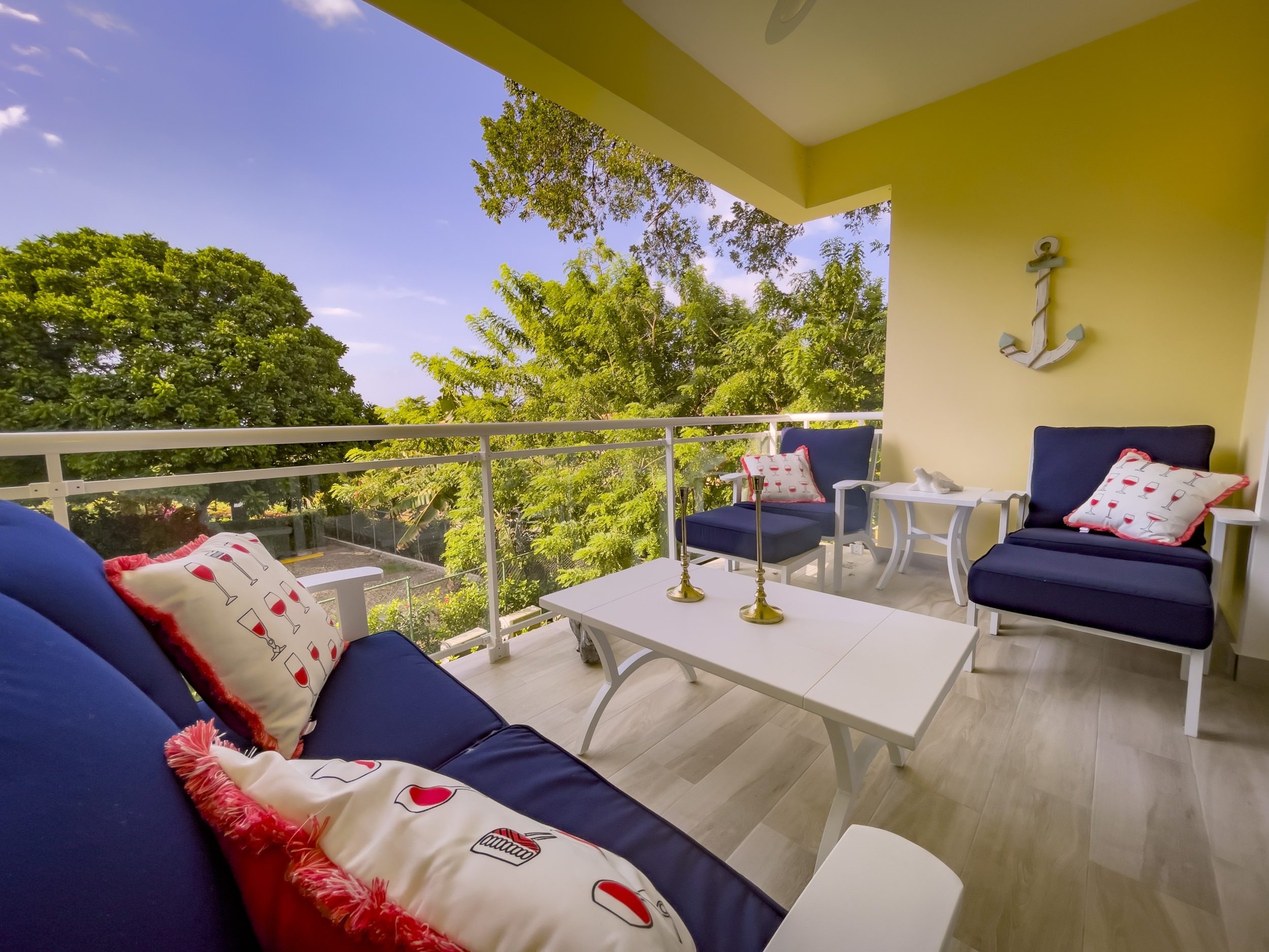 buyDRproperty Cozy outdoor seating area with blue cushions and pillows, offering modern comfort Sosua Real Estate