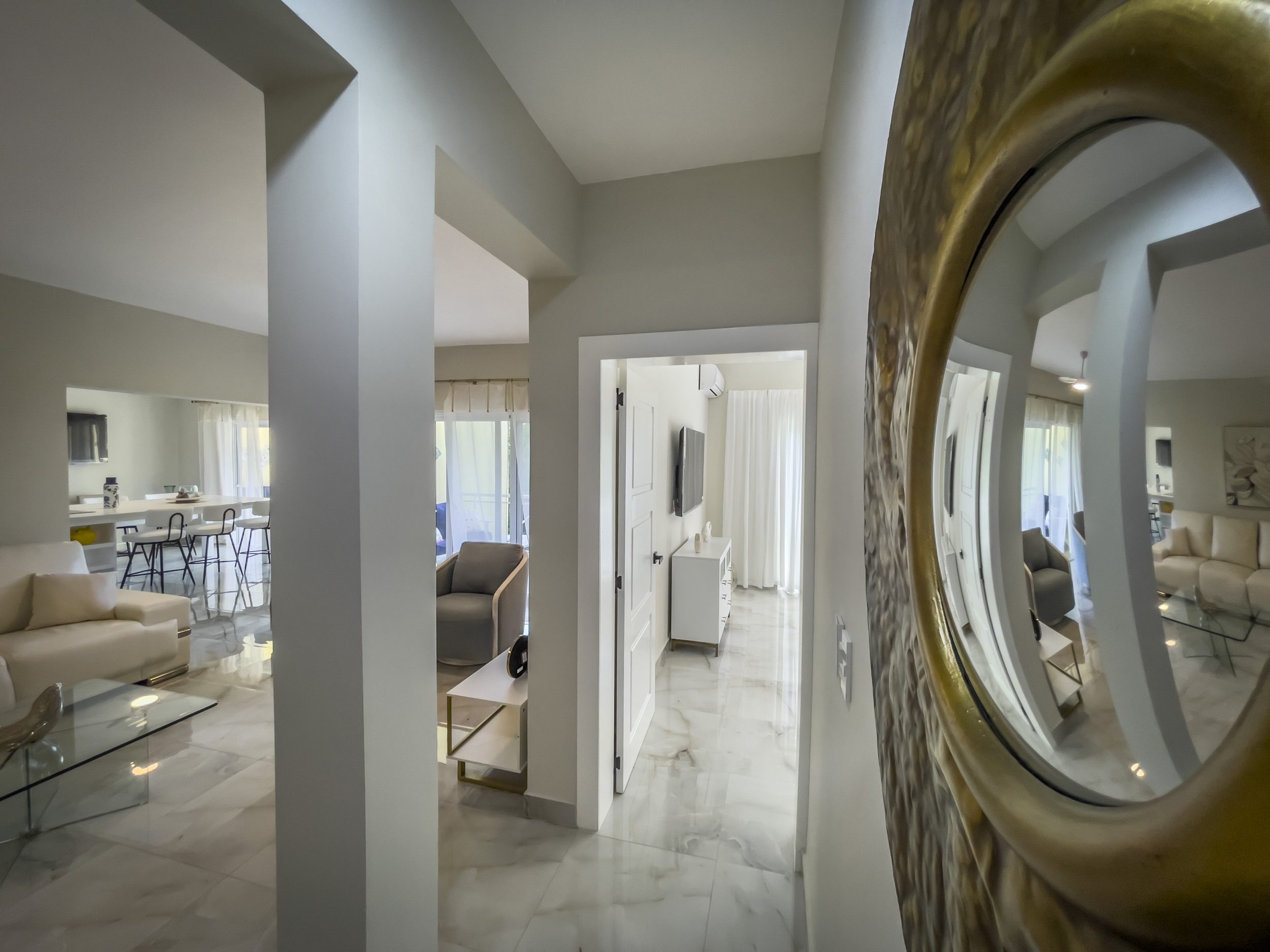 buyDRproperty Elegant hallway with a large mirror reflecting a modern living space, offering modern comfort. Sosua Real Estate