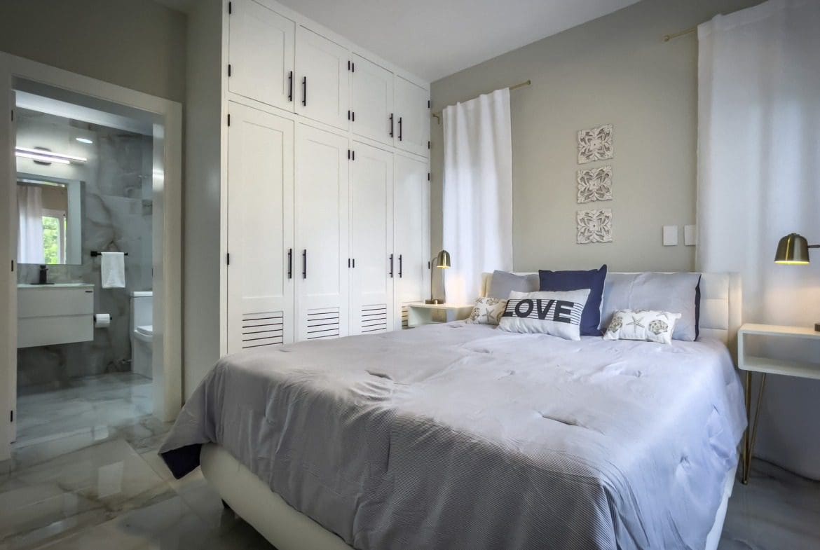 buyDRproperty Modern bedroom with white wardrobe and bed, offering modern comfort. Sosua Real Estate