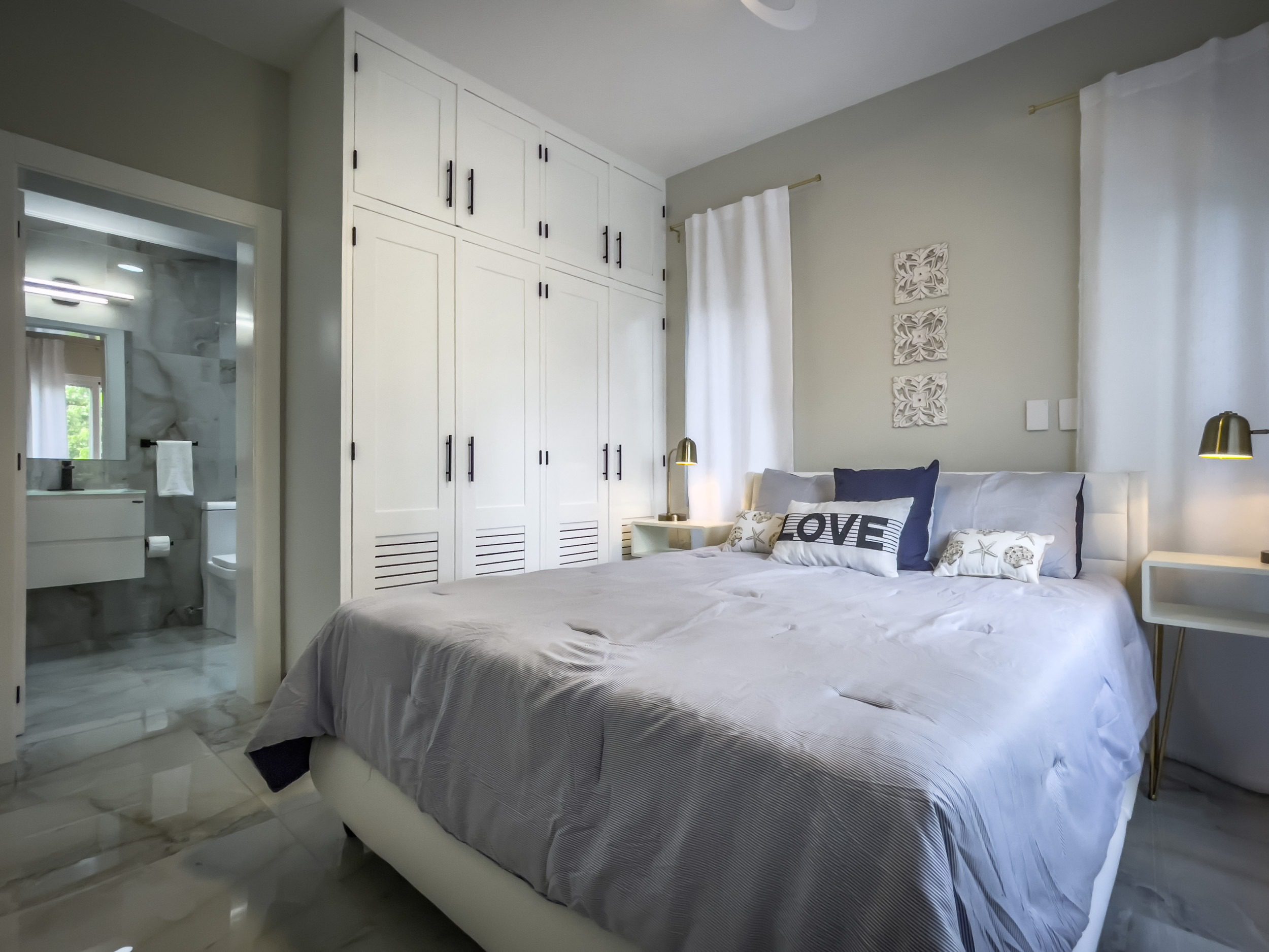 buyDRproperty Modern bedroom with white wardrobe and bed, offering modern comfort. Sosua Real Estate