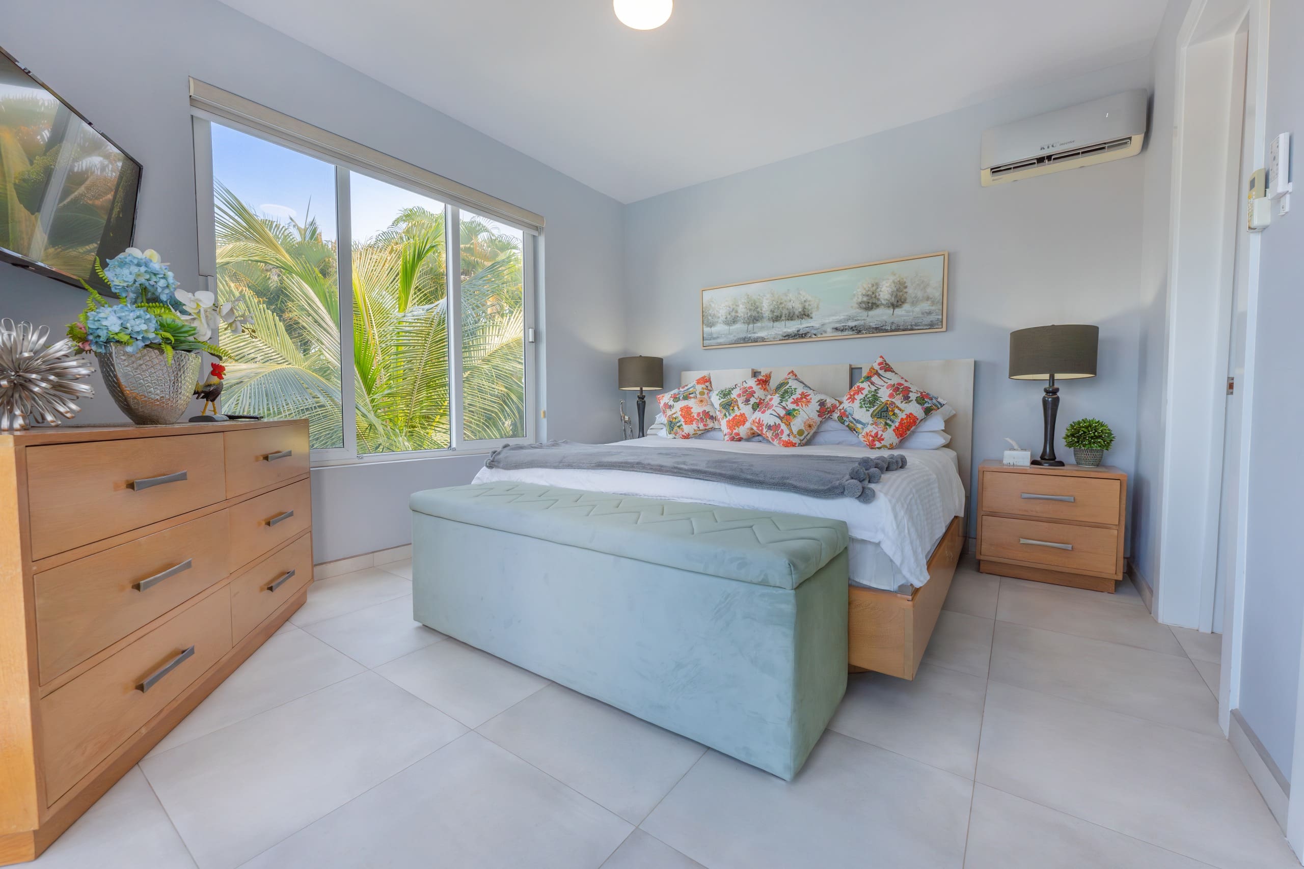 buyDRproperty 5 BR Luxury Villa bedroom with large bed, dresser, and palm tree view. Sosua Real Estate