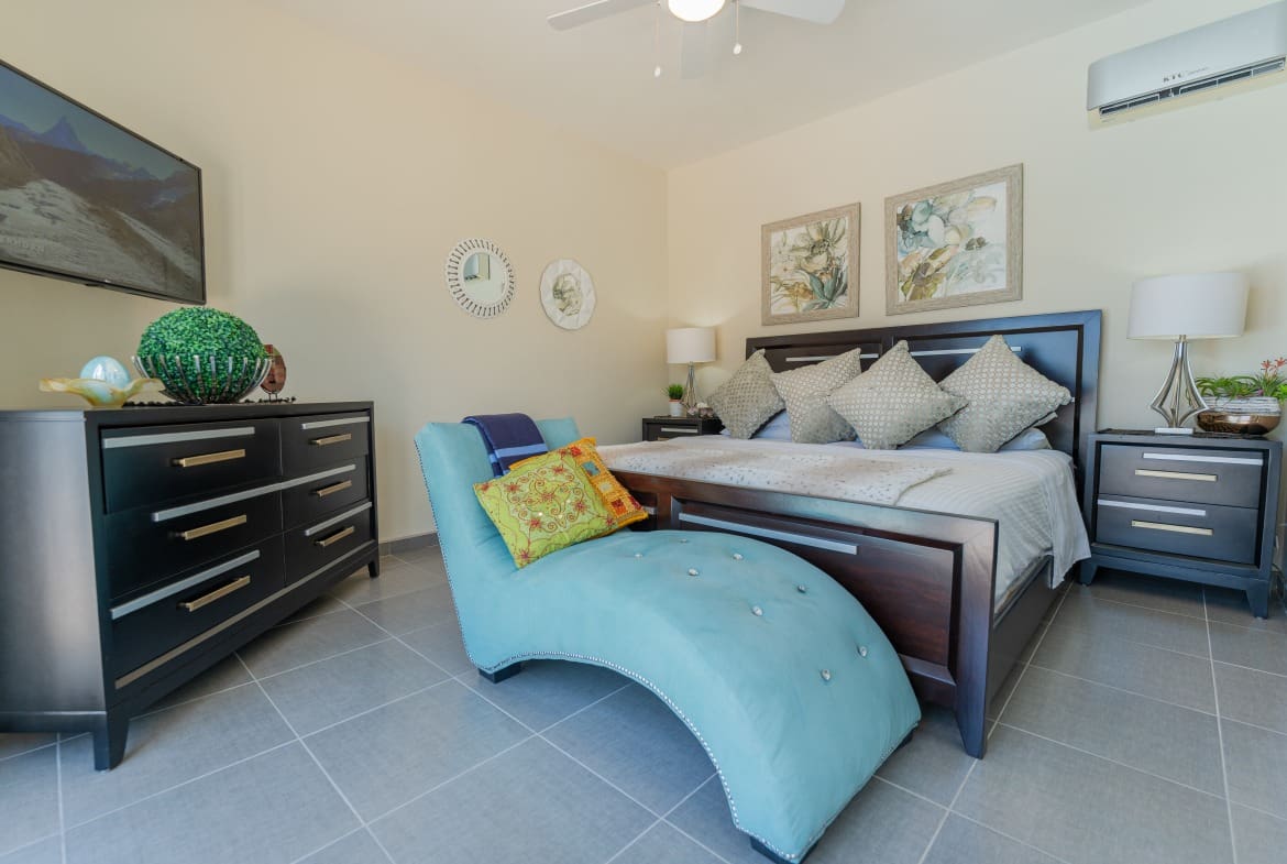 buyDRproperty Bedroom in a 5 BR Luxury Villa. Features a chaise lounge and dark wood furniture. Sosua Real Estate