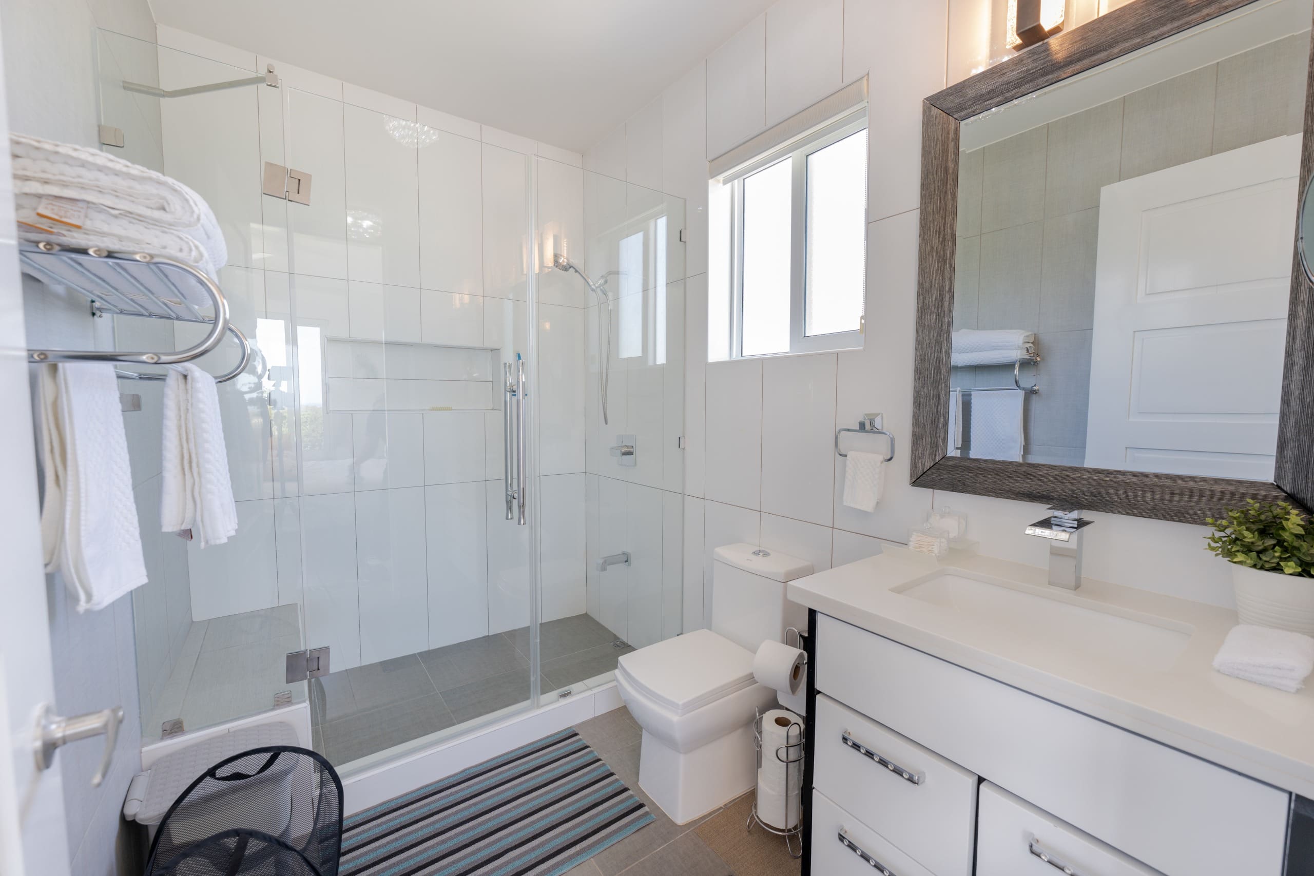 buyDRproperty Modern bathroom in a 5 BR Luxury Villa with glass shower and white tile. Sosua Real Estate