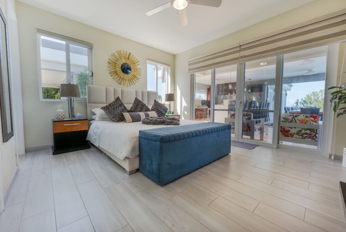 buyDRproperty Luxury bedroom in a 5 BR Luxury Villa with large windows and bright decor. Sosua Real Estate