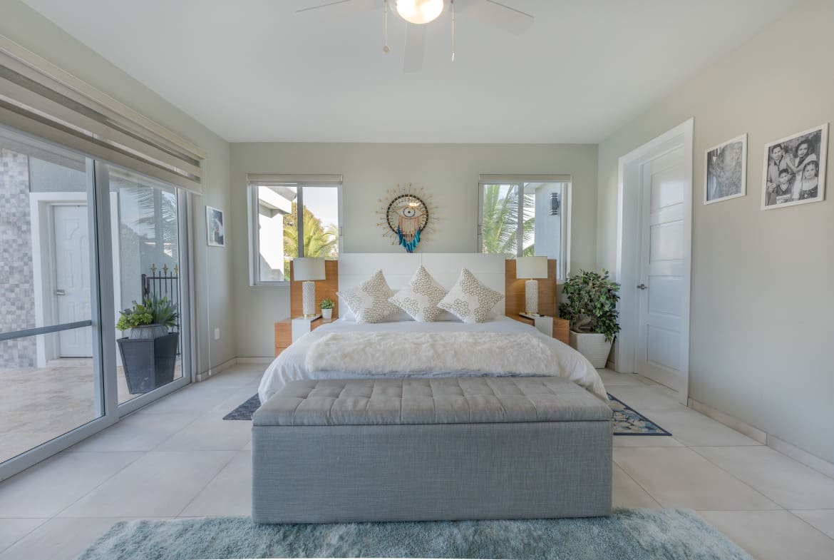 buyDRproperty Elegant bedroom in a 5 BR Luxury Villa, featuring a plush rug and large windows. Sosua Real Estate