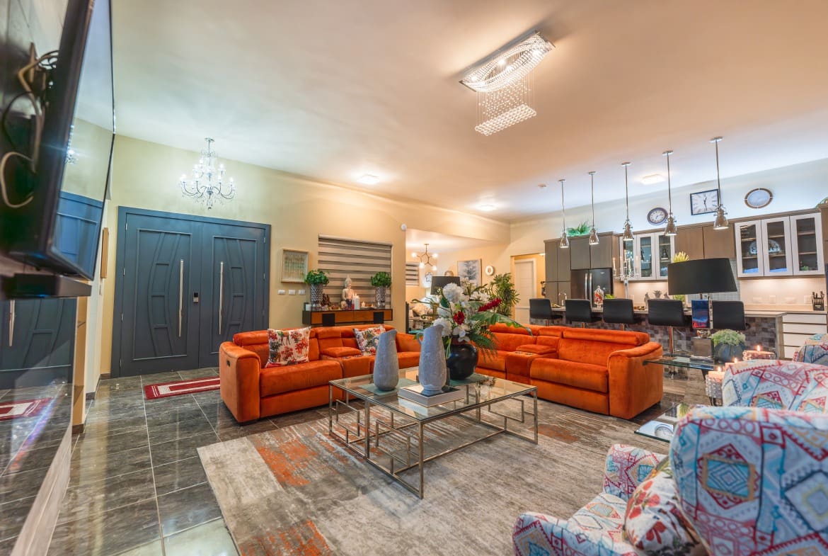 buyDRproperty Luxury living room with orange sofas in a 5 BR Luxury Villa. Sosua Real Estate