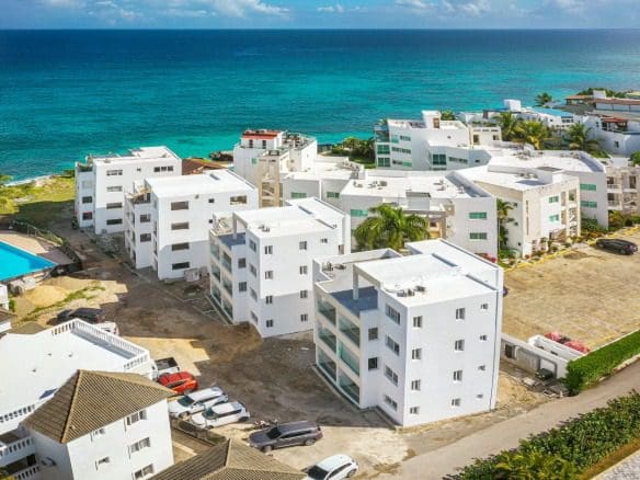 buyDRproperty Aerial view of white coastal properties with ocean view, perfect for beachfront living. Sosua Real Estate