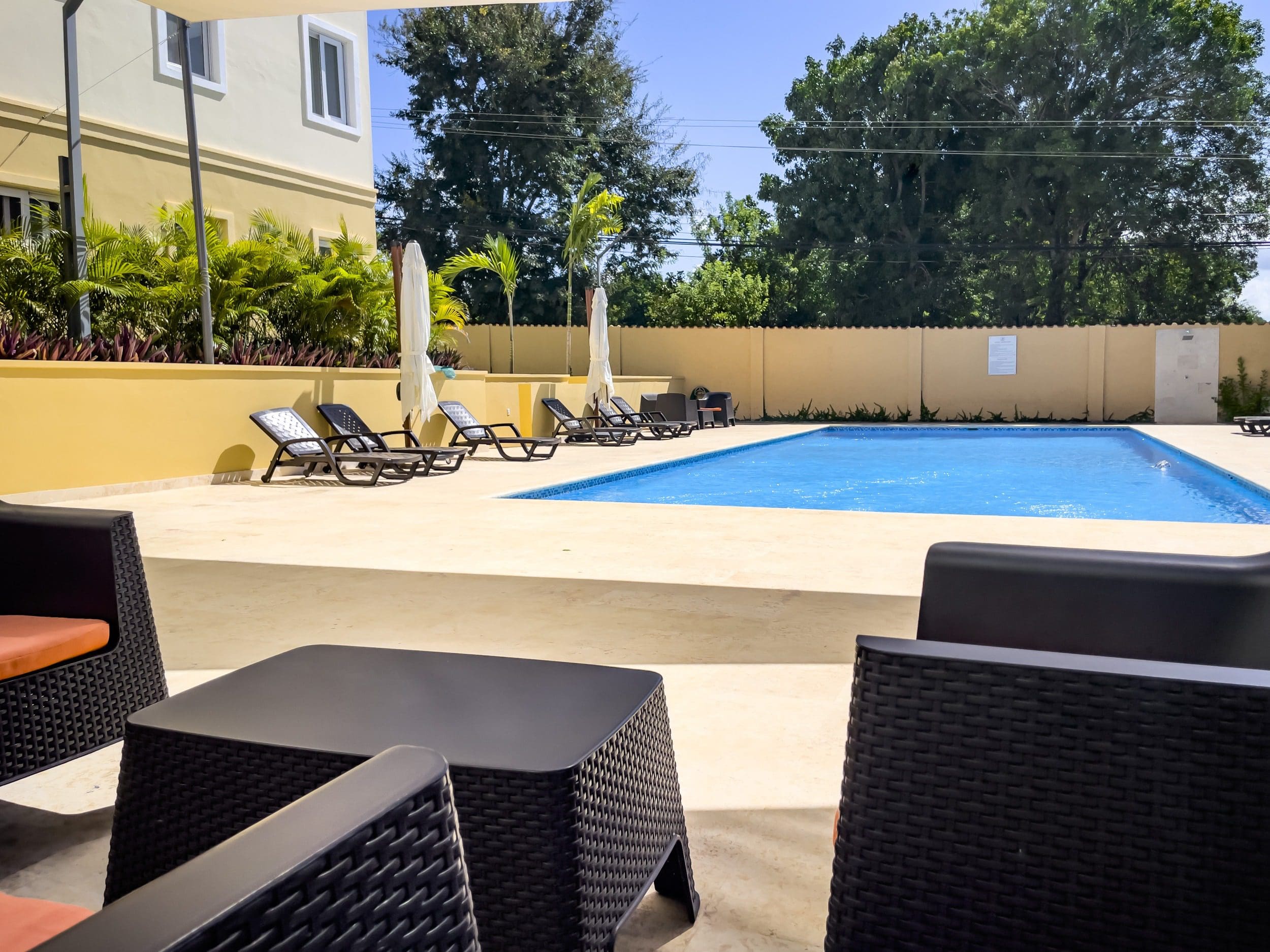 buyDRproperty Poolside lounge area with modern furniture at a modern 1-bedroom condo. Sosua Real Estate