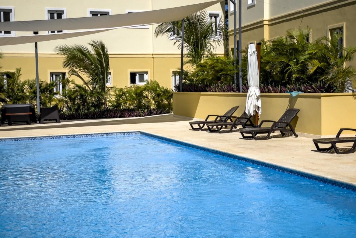 buyDRproperty Poolside lounge chairs at a modern condo Sosua Real Estate