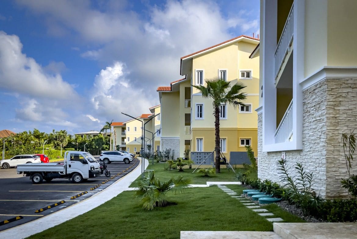 buyDRproperty Modern 1-bedroom condo complex with parking on a sunny day Sosua Real Estate