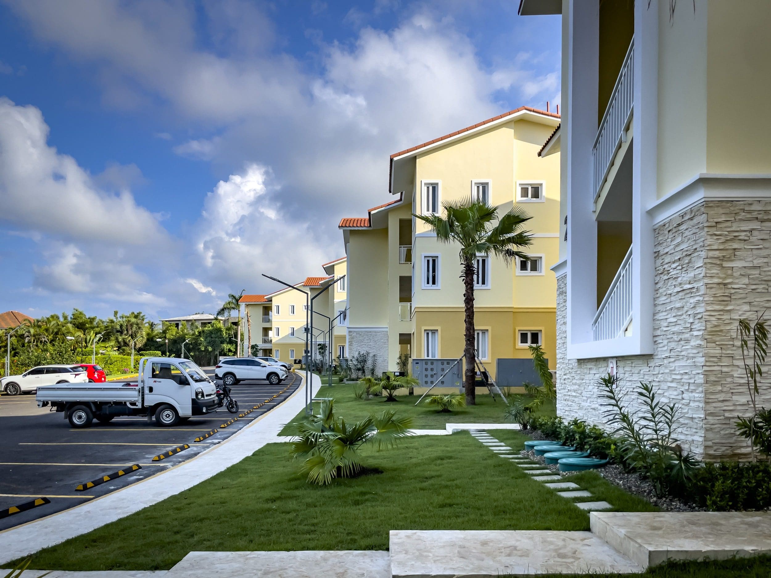 buyDRproperty Modern 1-bedroom condo complex with parking on a sunny day Sosua Real Estate